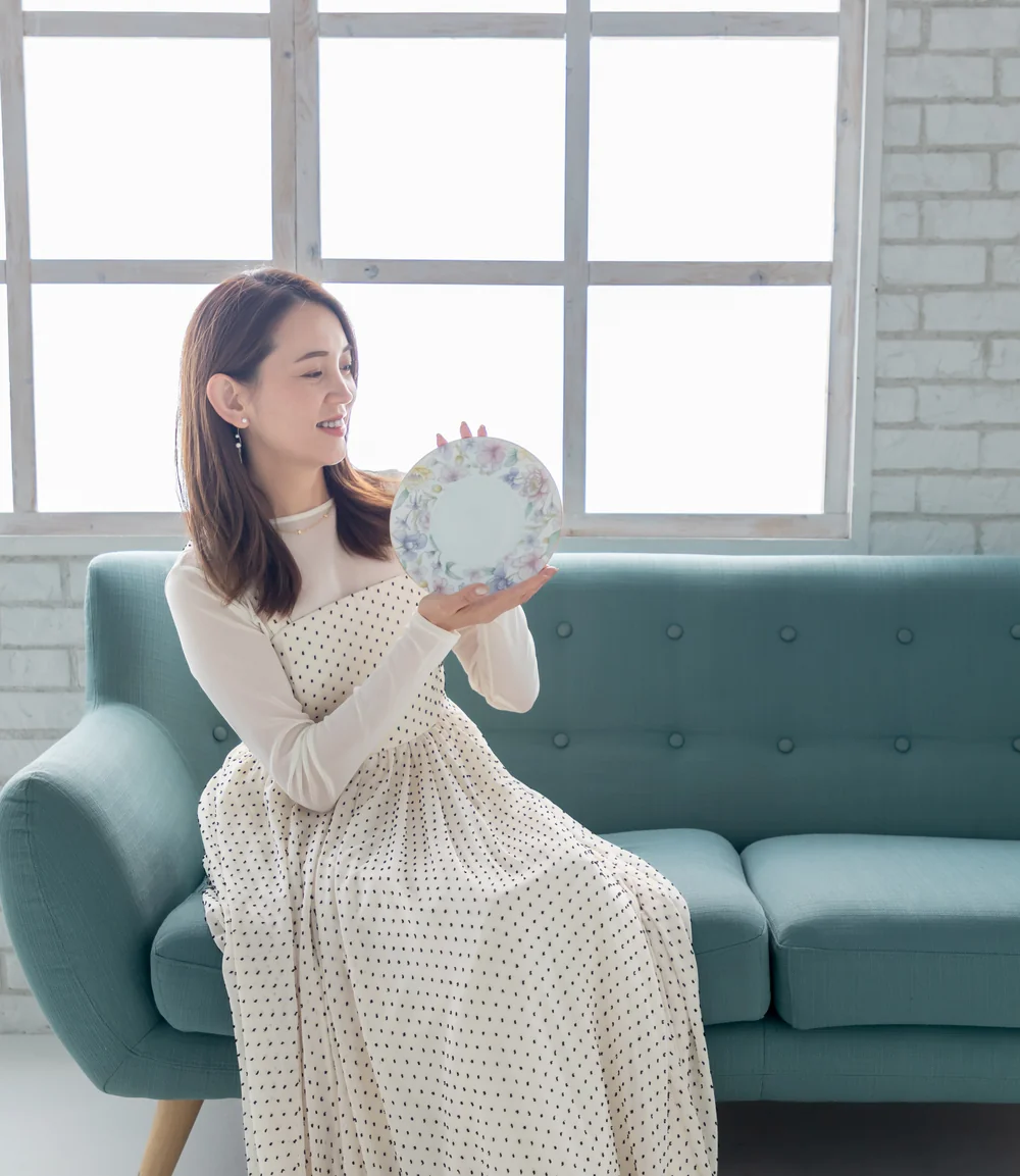 花柄のプレートを手に微笑む尾野さおり